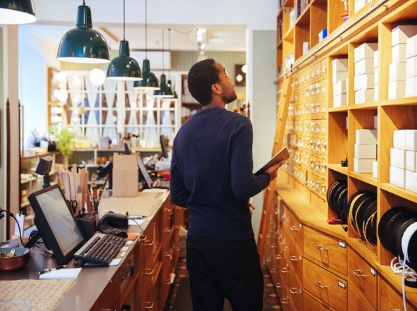 A professional reviewing inventory on shelves in a specialty shop